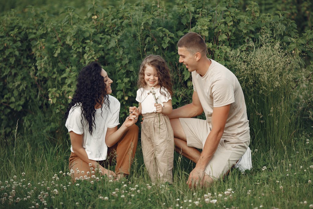 A joyful family enjoying time together in a lush green field.