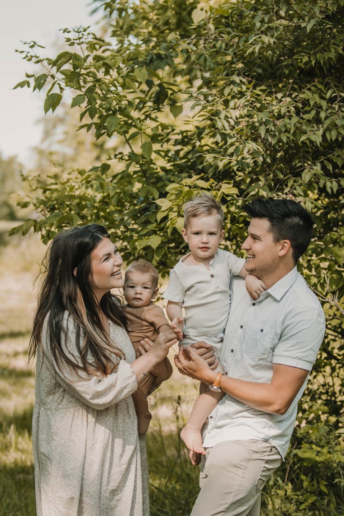 A joyful family of four enjoying a sunny day amidst lush greenery in Kansas City.